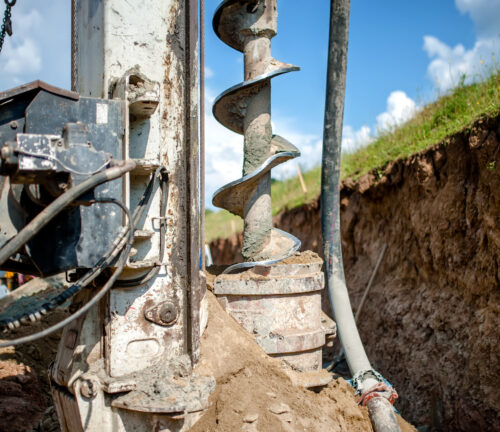 Close up of auger, industrial drilling rig making a hole in the ground